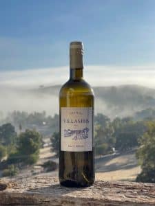 la bouteille du chateau de villambis vide devant un paysage naturel d'arbre et de brume