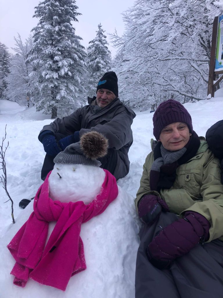 bonhomme de neige qui pose avec des personnes accompagnées